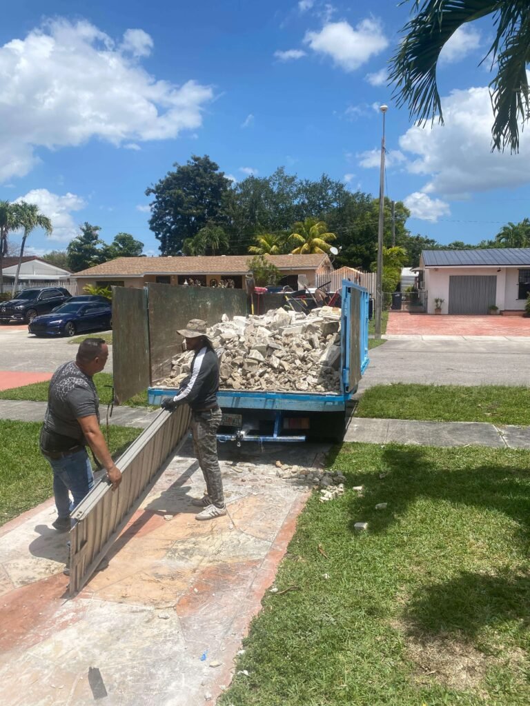crew loading construction debris into dumpster