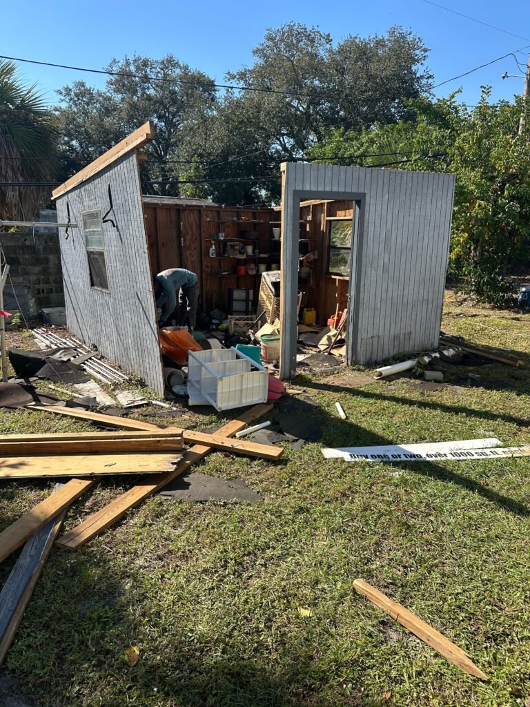 Shed demolition and removal in Melbourne FL — Dumpsters Wiz crew tearing down old wooden shed