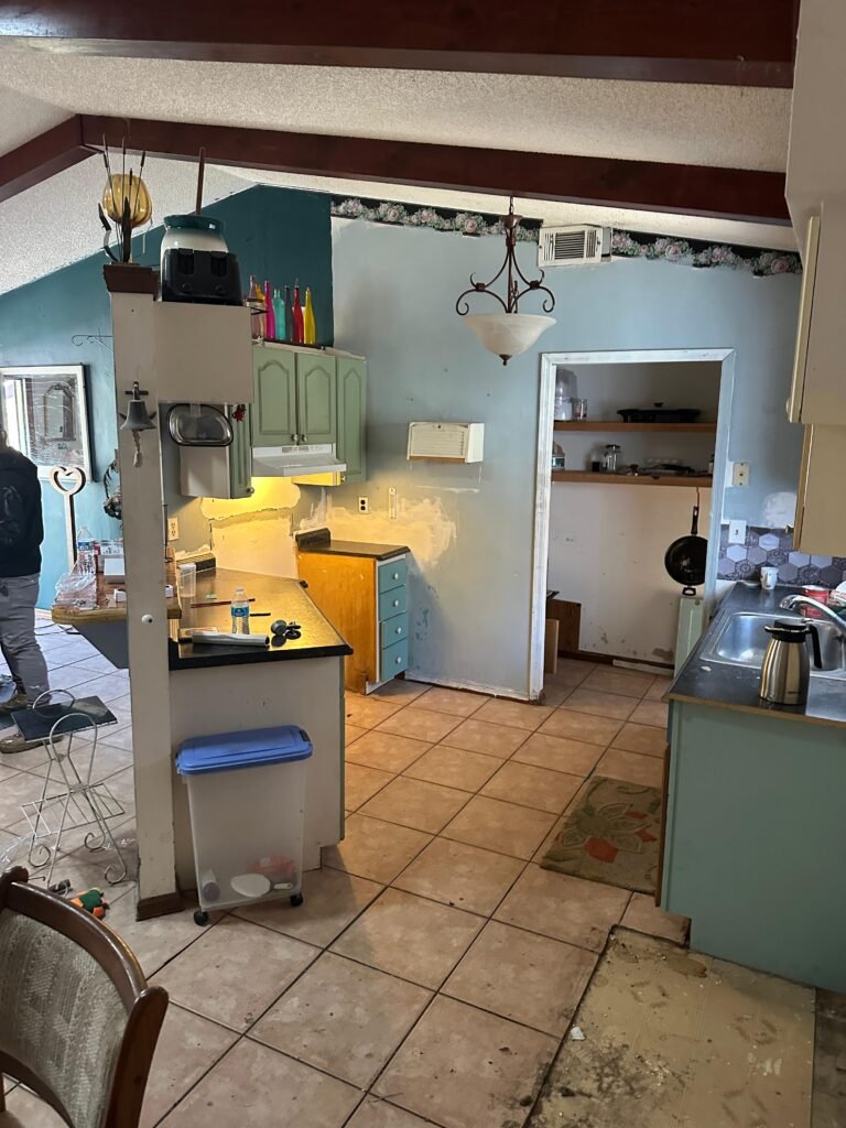 Kitchen mid-renovation with exposed walls and crew working