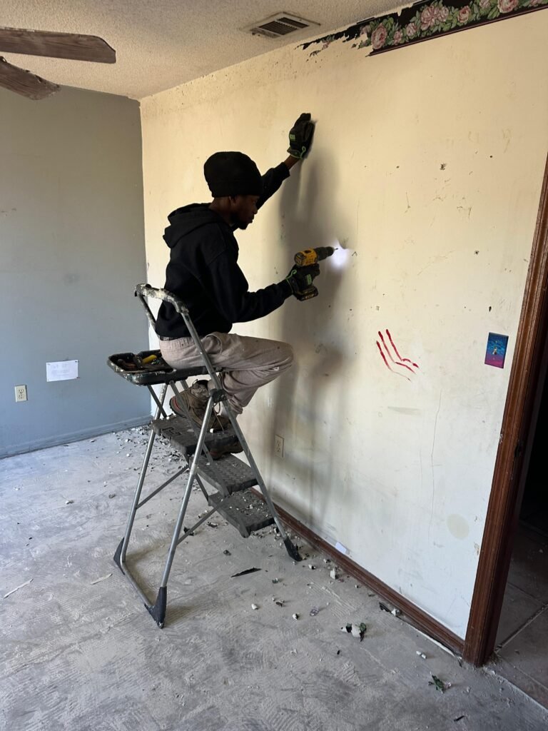 Crew member patching damaged wall during Palm Bay FL tenant eviction cleanout