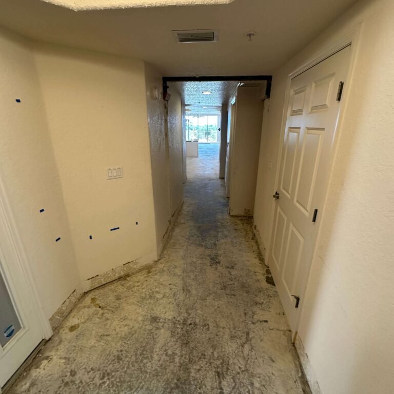 Hallway with flooring removed during interior demolition