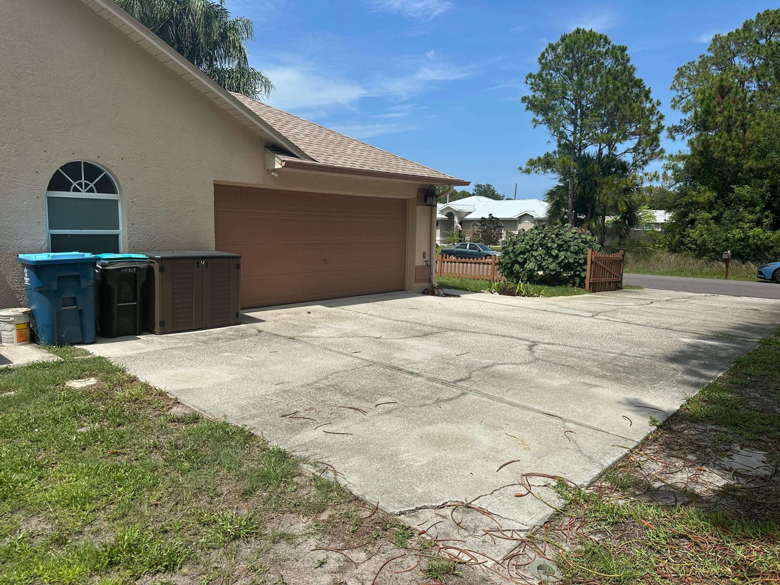 Cracked concrete driveway side view Palm Bay FL — driveway demolition before photo Dumpsters Wiz