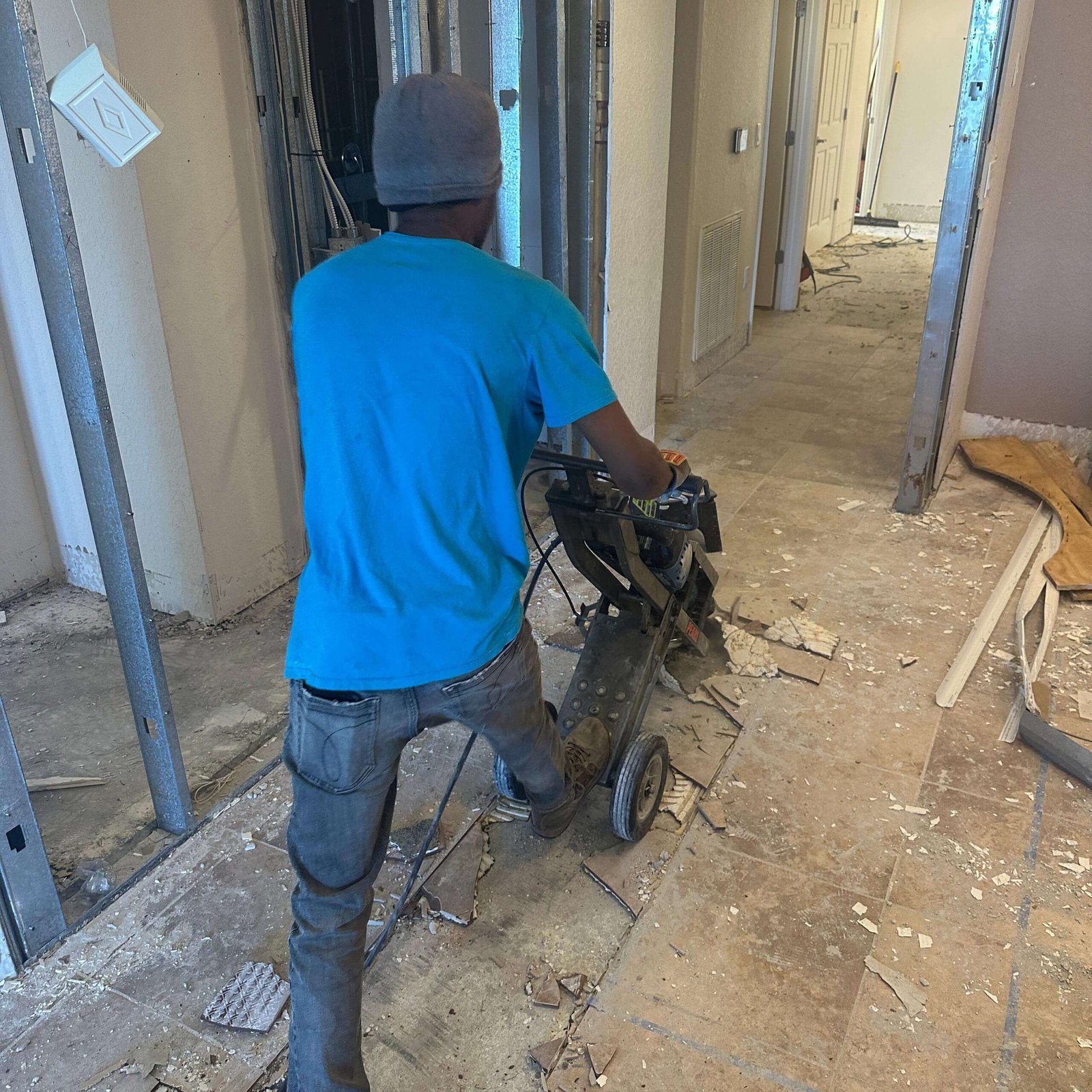 condo remodeling contractors crew removing tile flooring in Cocoa Beach Fl, Dumpsters Wiz Interiordemolition